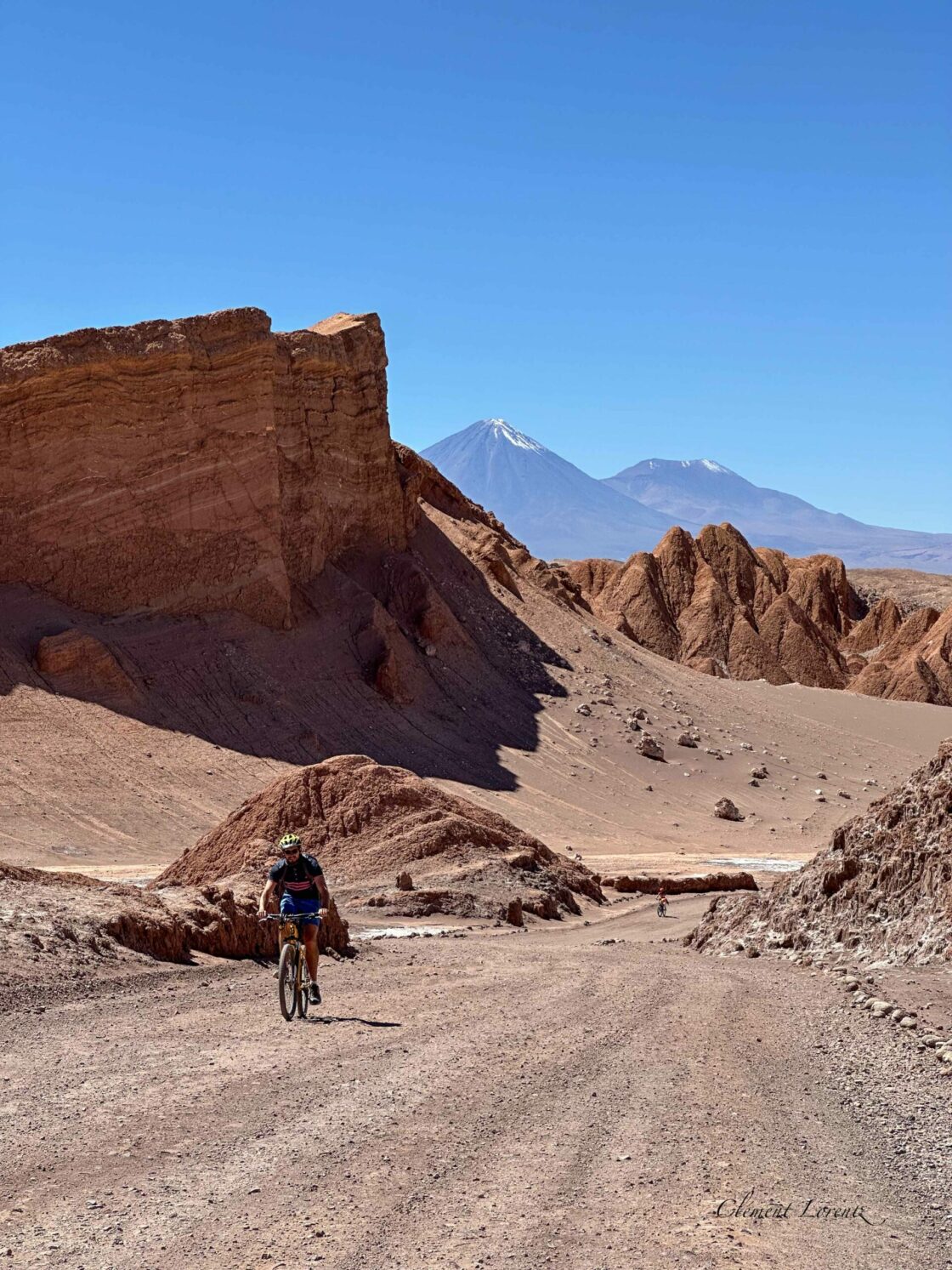 Vallee de la Lune Atacama Scenic view of Valle de la Luna amphitheater with a bicycle in the foreground and Licancabur volcano behind.