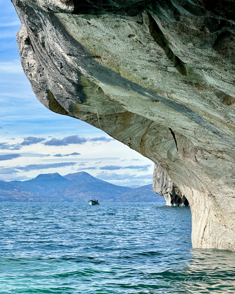 Capillas Marmol 2 View from a boat of the Marble Caves along General Carrera Lake, showing the unique rock formations and a small boat on the turquoise water in Patagonia, Chile