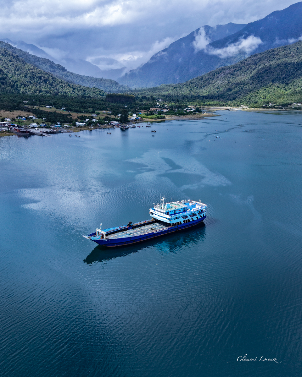 Hornopieren Boat Blue and white boat navigating the fjord near Hornopirén, Chile, surrounded by Patagonian mountains and waters
