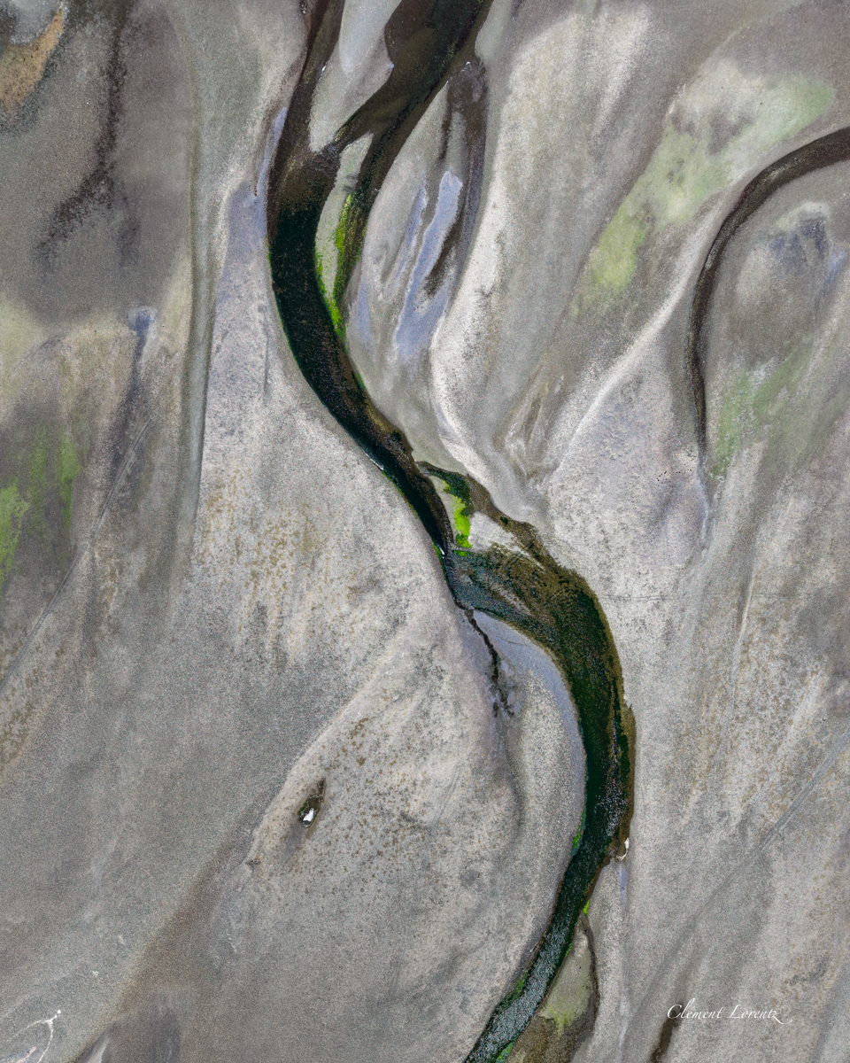 Riviere Carretera Austral 2 Top-down aerial view of a river flowing into a fjord along the Carretera Austral, Chile, revealing stunning colors and textured natural landscapes in Patagonia.