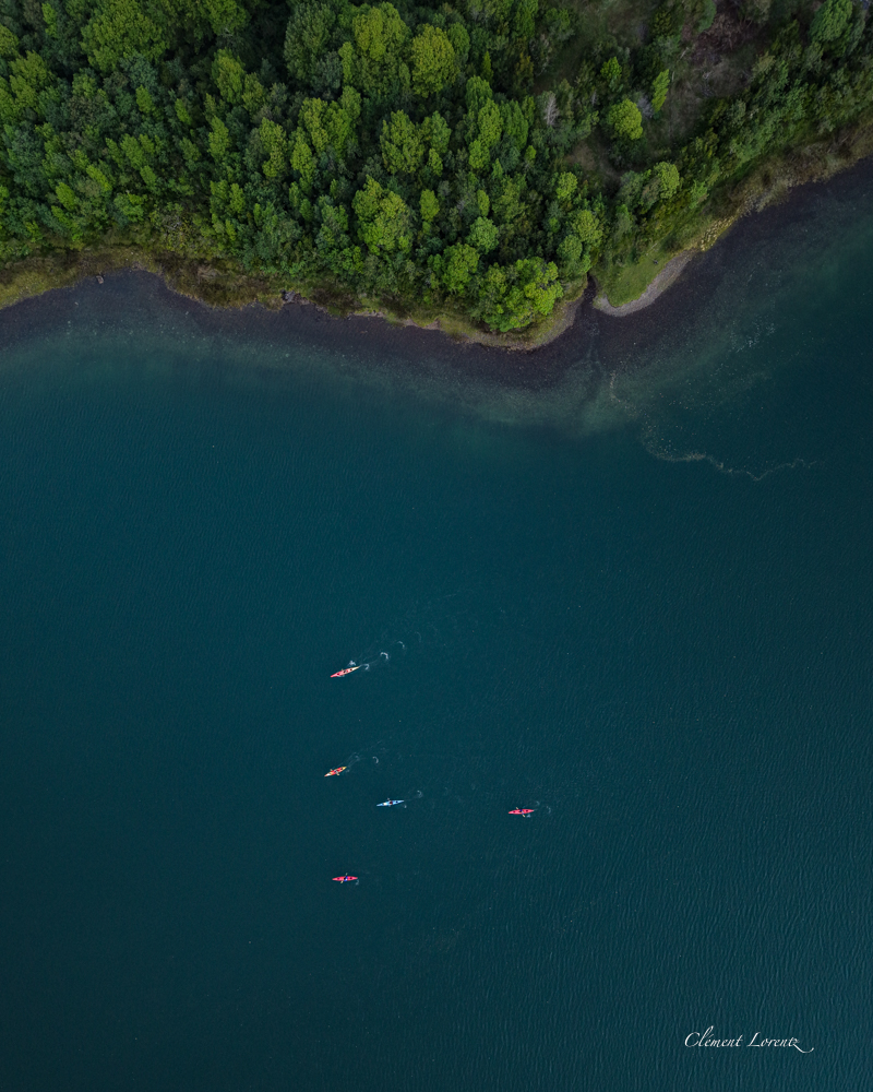 Topdown Kayak Puyuhuapi Aerial view of colorful kayaks at dusk in the Puyuhuapi Fjord along the Carretera Austral, Chile, surrounded by calm Patagonian waters
